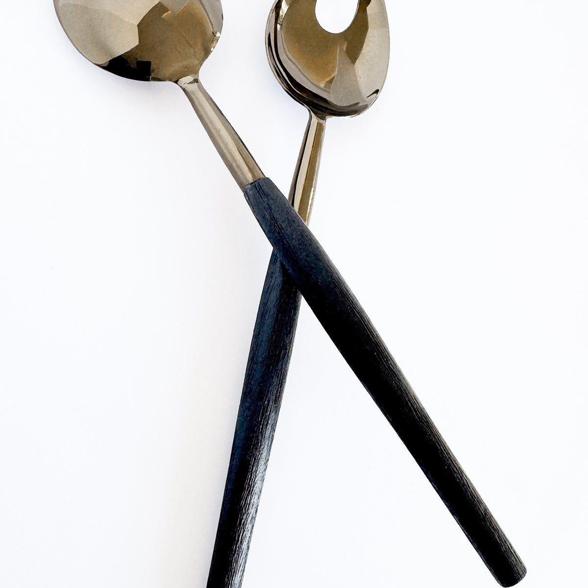 M. By Design - Curated tabletop essentials. Two spoons with gold and black handles on a white background