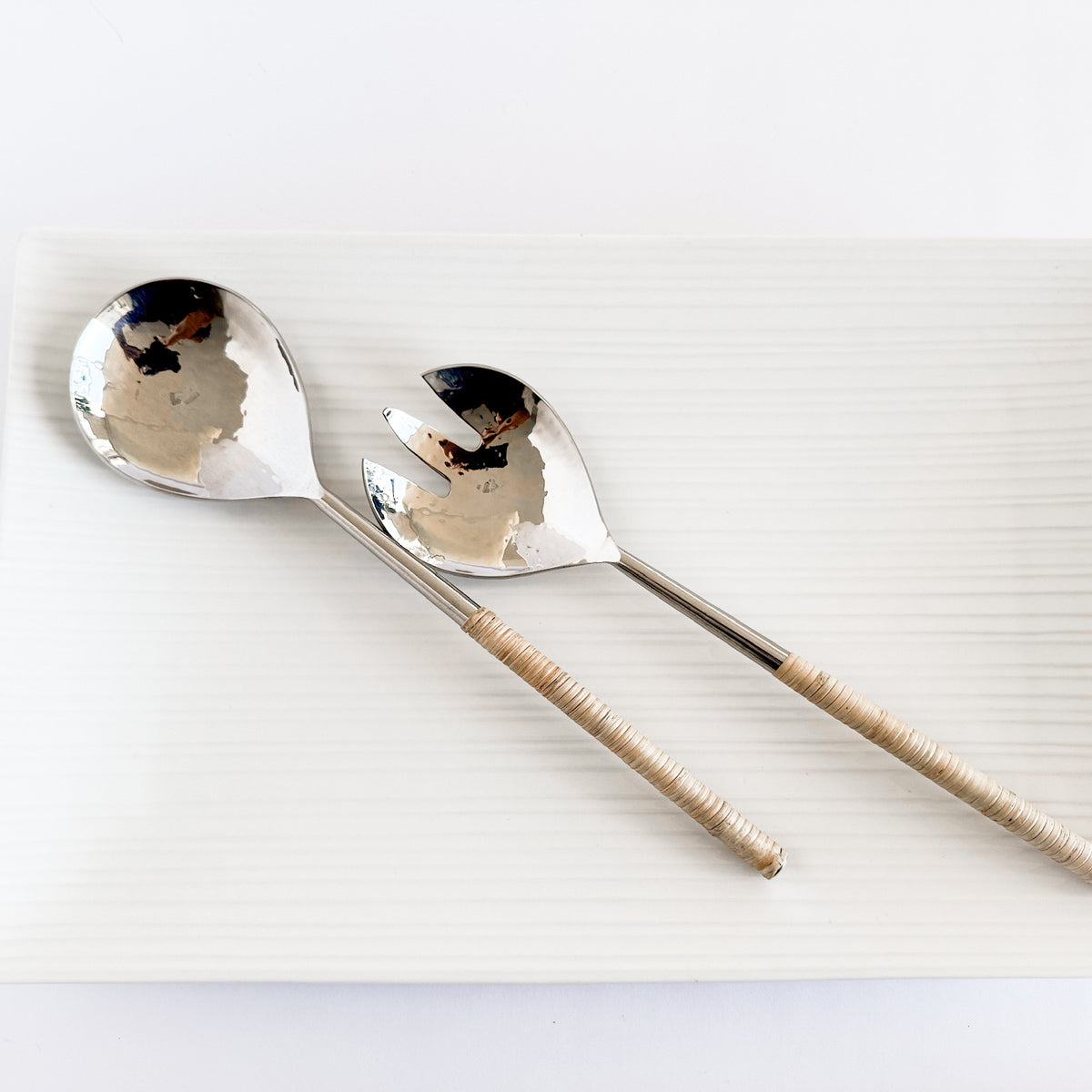 M. By Design - Curated tabletop essentials. Two silver spoons with woven handles on a white background