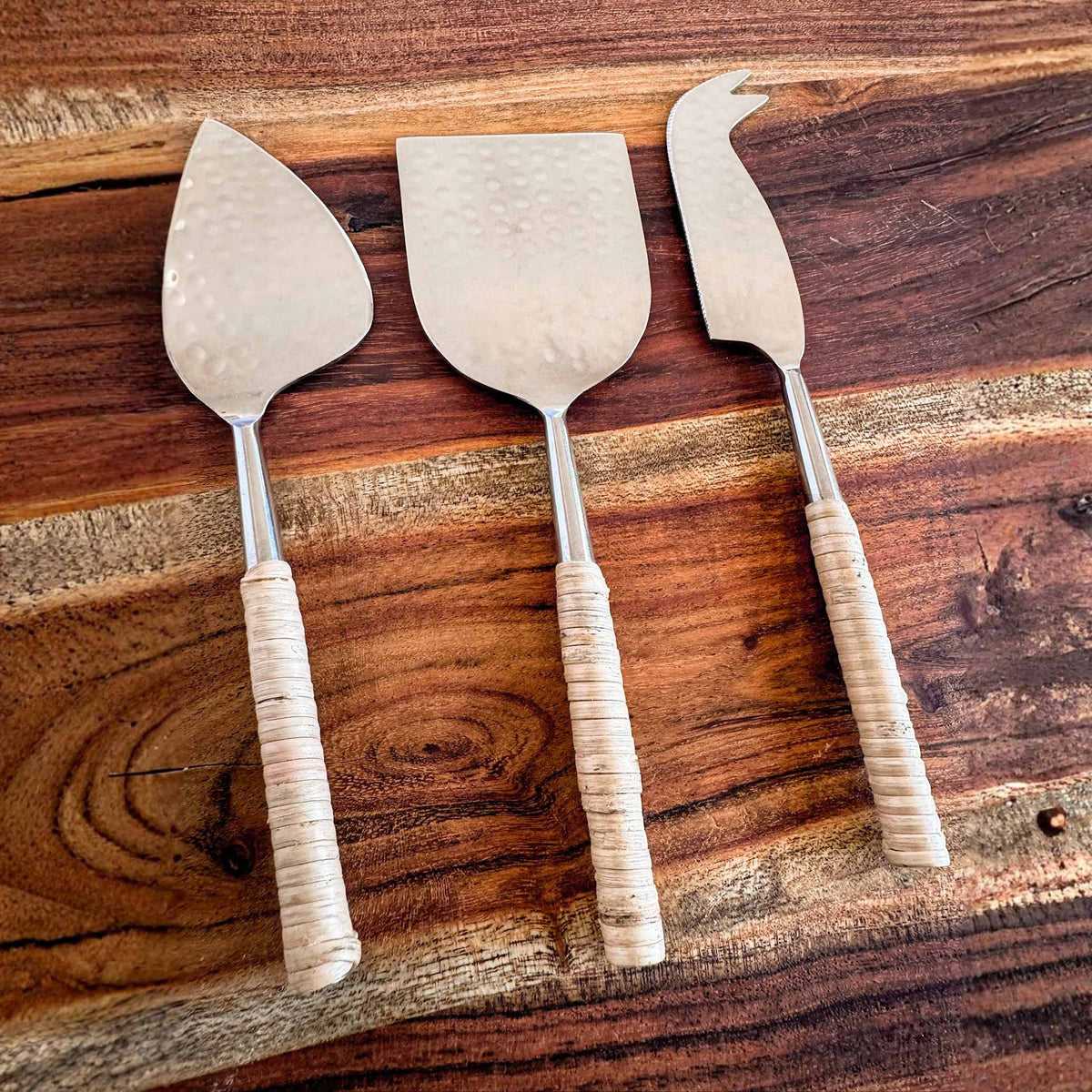 M. By Design - Curated tabletop essentials. Three cheese knives with wooden handles on a wooden surface
