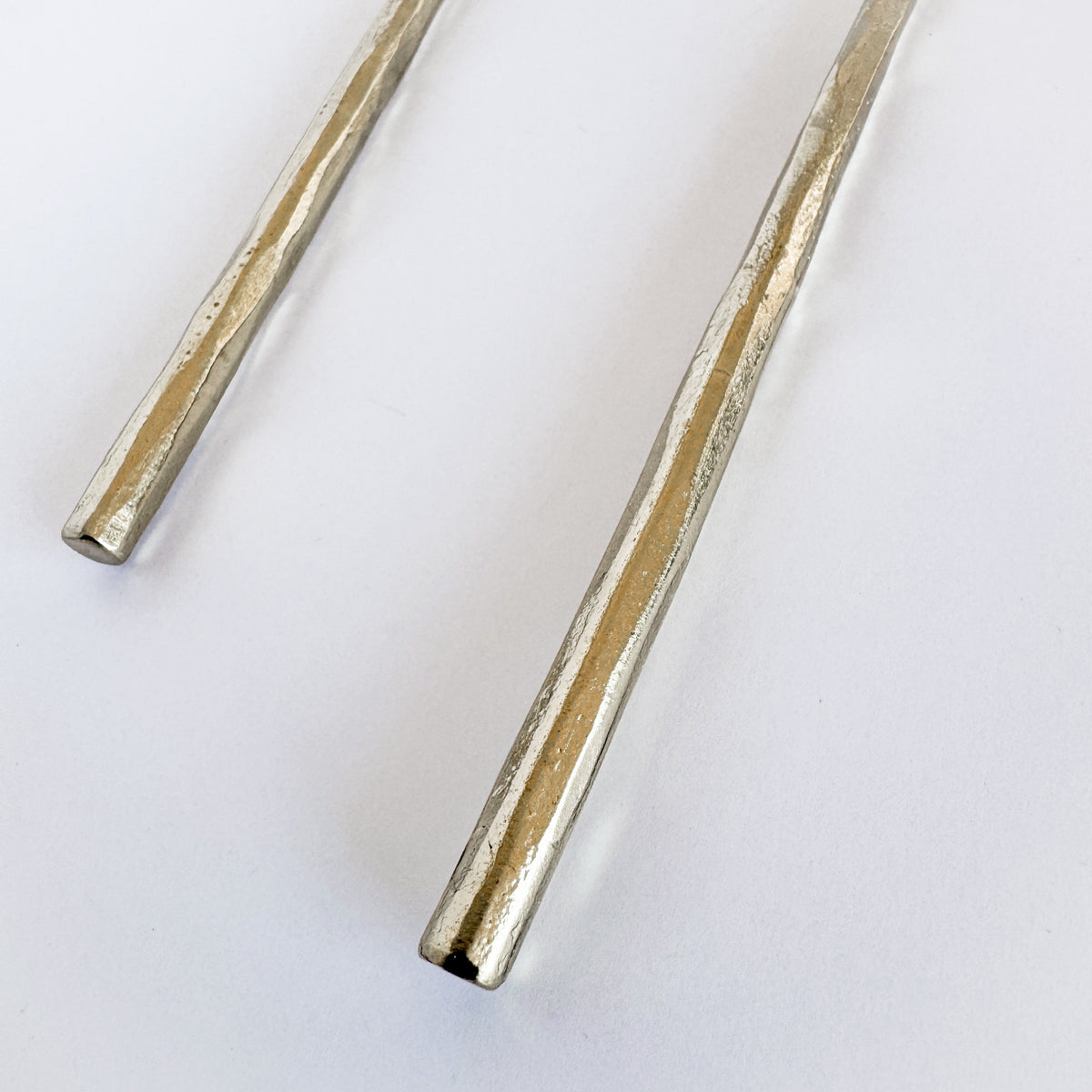 M. By Design - Curated tabletop essentials. Two metallic cylindrical objects on a white background