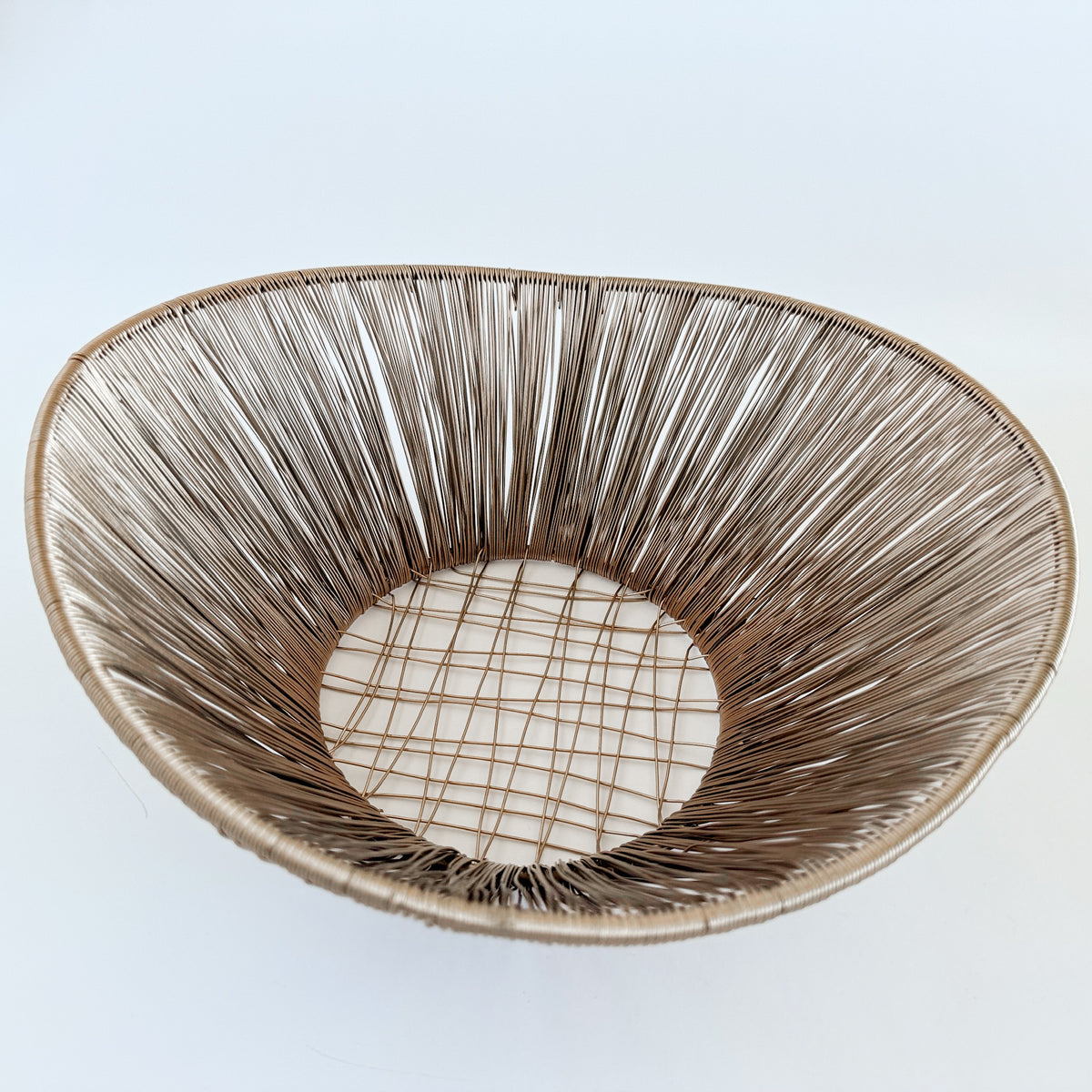M. By Design - Curated tabletop essentials. Woven basket with a circular design on a light blue background